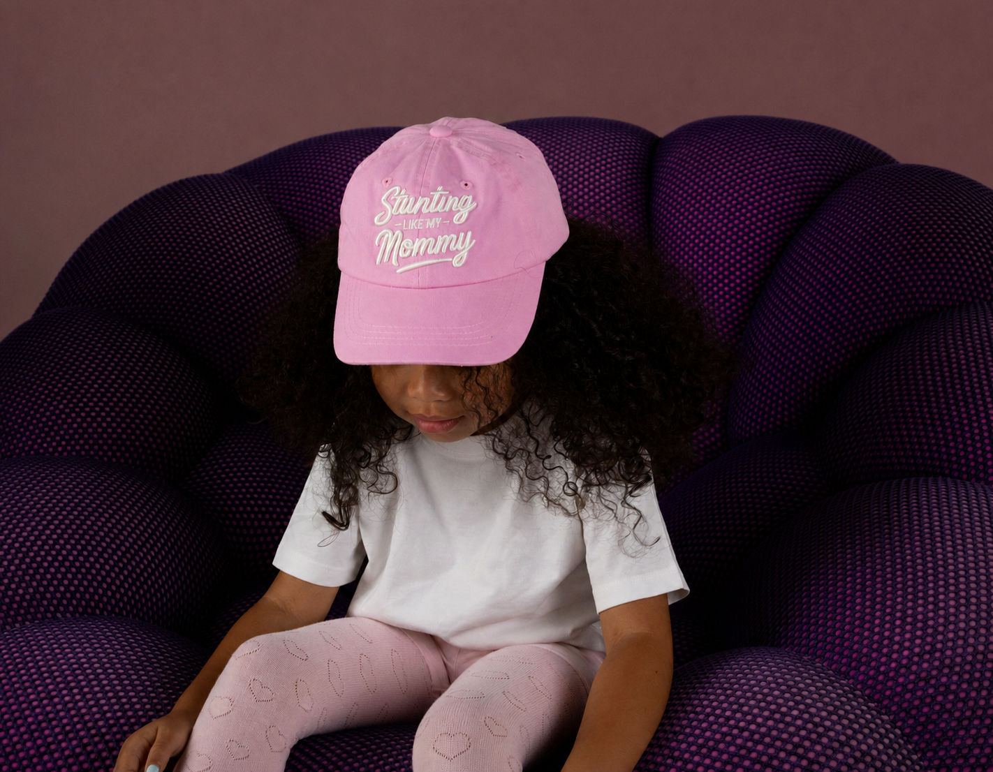 A child showing the detail of their pink hat